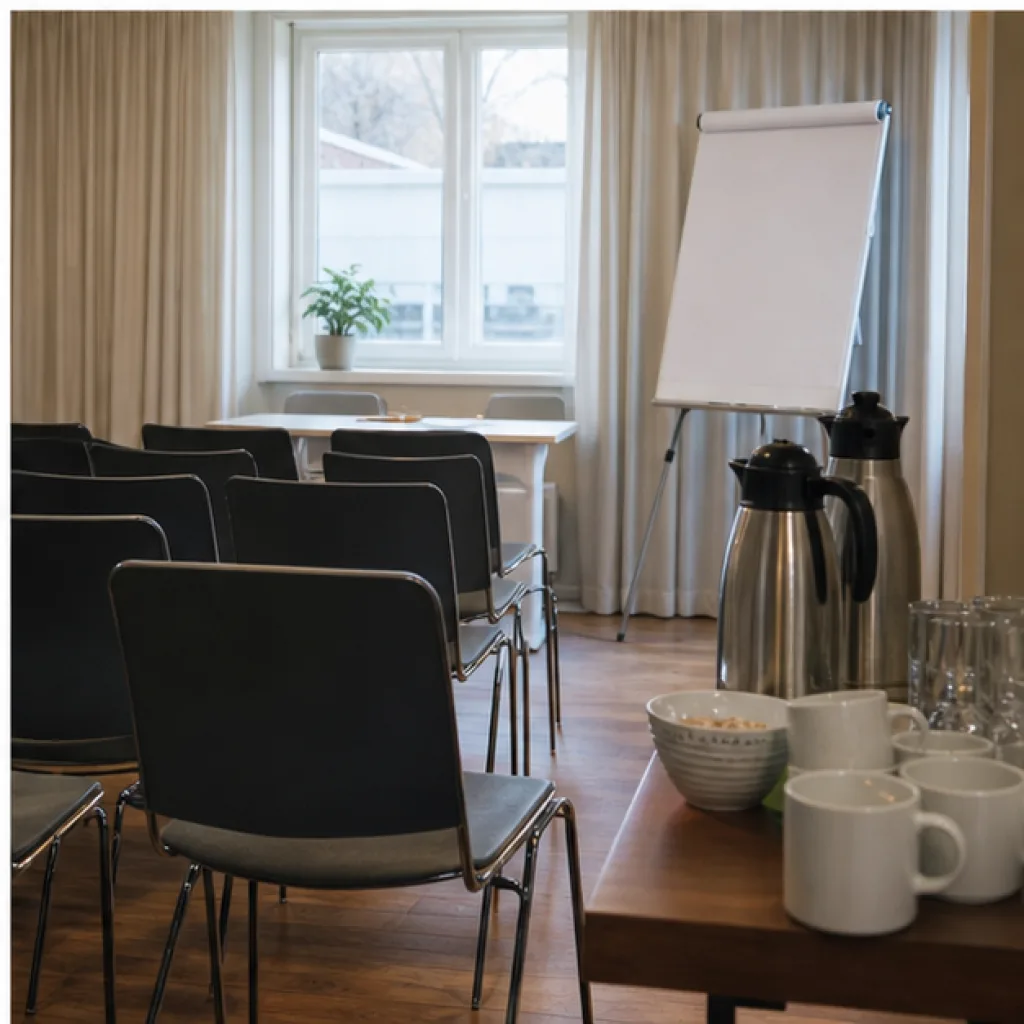 Konferensrum med stolar, blädderblock och kaffe inför gruppens möte