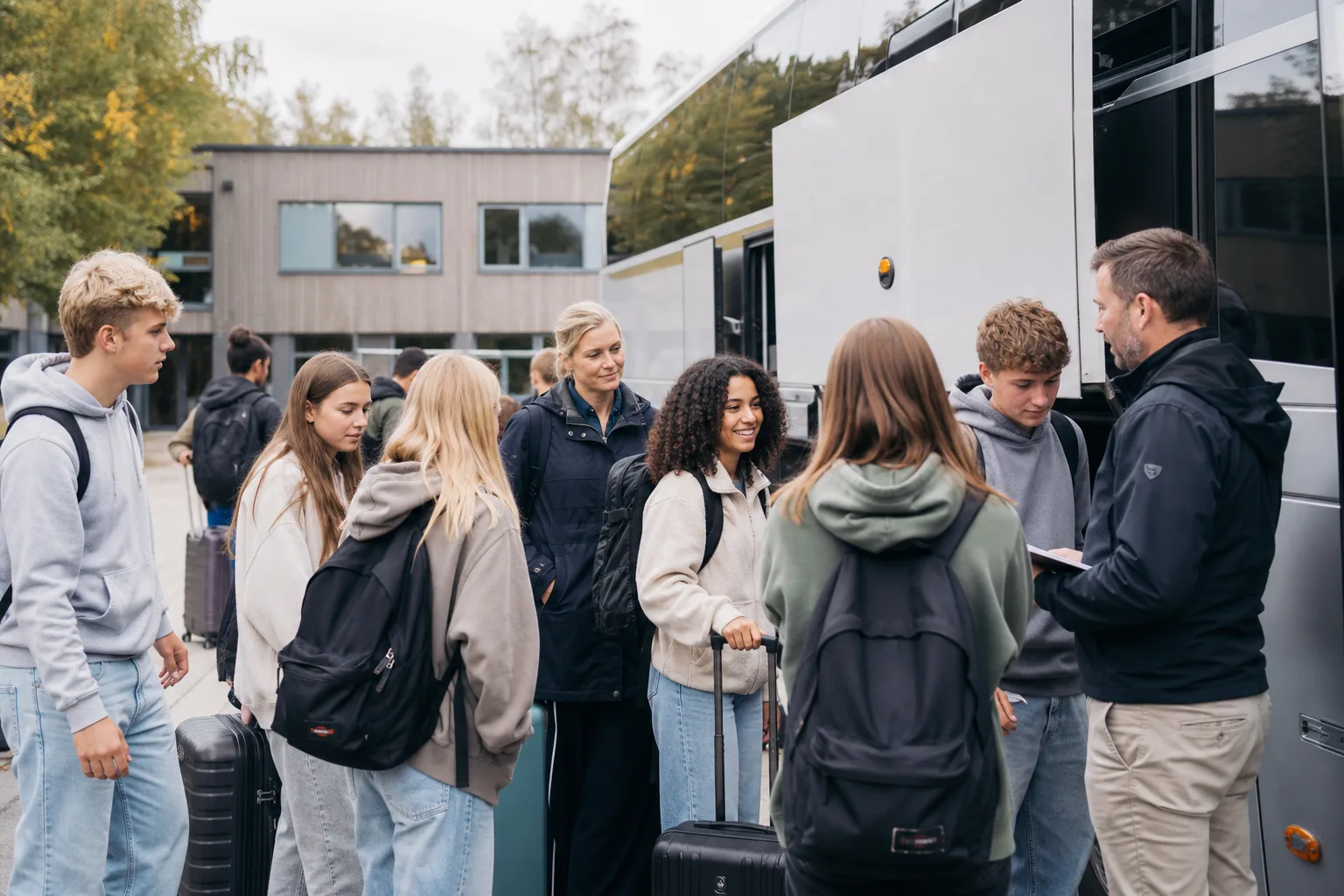 Elever och lärare går ombord på en buss inför en skolresa